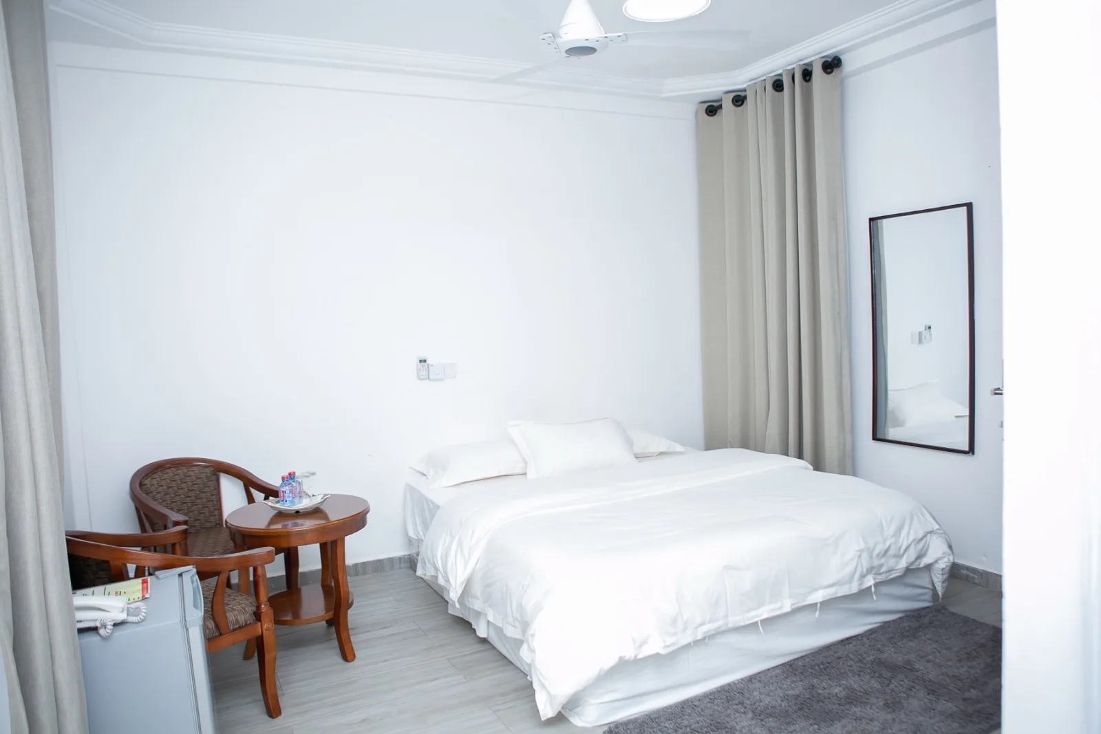 A bright guest room with rattan chairs