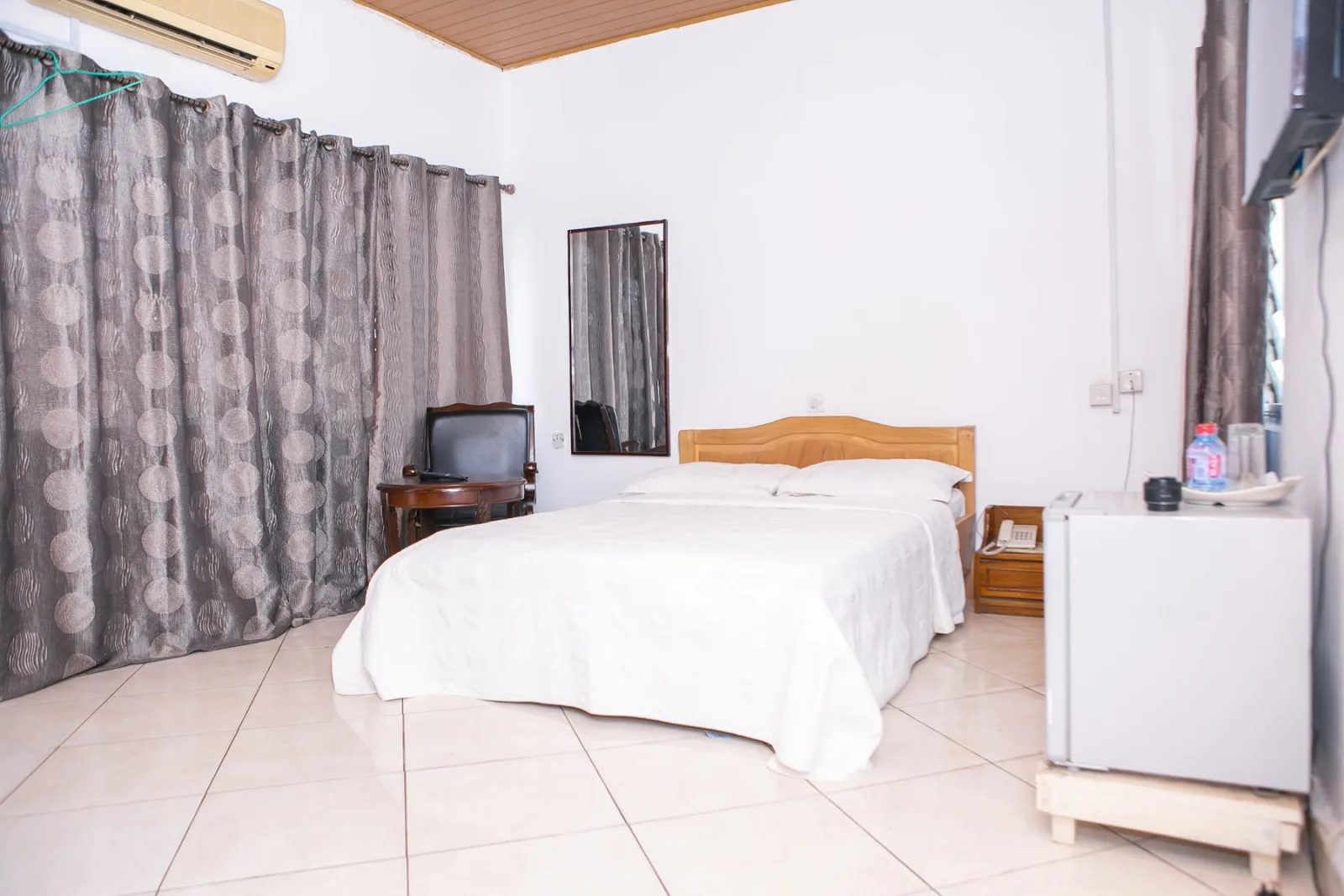 A guest room with television and fridge