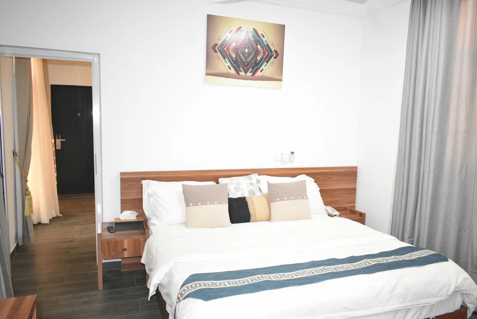 A guest room with a wooden headboard
